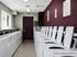 Modern laundry room with rows of efficient washing machines and vibrant maroon accent wall.