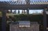 Charming outdoor space with a stone-built BBQ grill under a stylish pergola, ideal for entertaining and enjoying sunny days.
