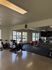 Bright fitness center featuring stationary bikes, exercise mats, and vibrant workout space with large windows.