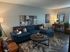 Cozy living room with stylish blue sofa, modern artwork, and chic decor, perfect for relaxation and entertaining.