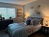 Cozy bedroom with a chic ambiance, featuring a plush bed, stylish lamps, and tasteful wall art.