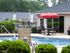Hunters Run outdoor pool area with clubhouse and umbrella table and lounge chair.