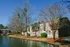 Club Hill Apartments Exterior: View of 2 level buildings, trees, and water.