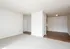 Bright open-concept living space with plush carpet and sleek wood flooring.