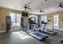 Bright and spacious fitness center with modern treadmills and strength training equipment in a luxury apartment complex.