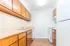 Bright kitchen featuring wooden cabinetry, countertops, modern appliances, and white walls.