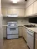 Charming and efficient kitchen with modern appliances, ample cabinetry, and sleek design.
