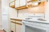 Bright kitchen with modern white appliances, wood-trimmed cabinets, and clean countertop.