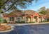 Inviting residential facility with brick and stone facade, surrounded by lush greenery.