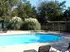 Inviting outdoor swimming pool surrounded by lush greenery and comfortable seating, perfect for relaxation.