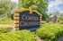 Inviting entrance sign for Corder Crossing surrounded by lush greenery and trees.
