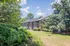 Charming apartment building with lush greenery and sunny skies.