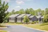 Charming apartment complex surrounded by lush greenery and a clear blue sky.