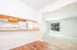 Inviting open kitchen with wooden cabinets, overlooking a bright living room with sliding glass doors to a lush garden.