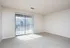 Spacious living room with plush carpet and sliding glass doors leading to a balcony.