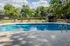 Inviting residential pool area surrounded by lush green trees and comfortable lounge chairs.