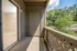 Inviting balcony space overlooking lush greenery, featuring a sliding door leading to the living room.