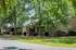 Serene apartment building surrounded by lush green trees and manicured lawns.