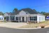 Beautiful single-story home with a gabled roof, white siding, and a spacious driveway.