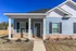 Inviting blue bungalow with white trim and welcoming porch.