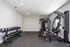 Sleek gym featuring a full set of dumbbells and modern exercise equipment in a bright, spacious room.