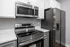 Contemporary kitchen with stainless steel appliances, including a stove, microwave, and refrigerator.