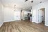 Contemporary open-concept kitchen and living area with elegant wood flooring and neutral walls.