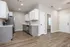 Sleek, modern kitchen with stainless steel appliances, white cabinets, and elegant wood flooring.