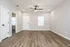 Bright open living room with wooden floors, a ceiling fan, and neutral walls.