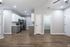 Modern kitchen with sleek appliances and spacious living area featuring hardwood flooring and neutral tones.