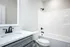 Bright and sleek bathroom featuring a stylish sink, classic white bath, and elegant black fixtures.