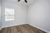 Spacious and light-filled room with modern wood flooring and a large window.
