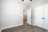 Spacious room with modern laminate flooring, fresh white walls, and double-door closet.
