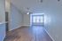 Spacious, bright living area with elegant wooden flooring, large window, and modern ceiling fan, perfect for open-concept living.
