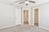 Bright bedroom with a ceiling fan, soft carpet, ensuite bathroom, and spacious walk-in closet, perfect for modern living.
