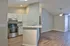 Modern open-concept kitchen and living area with sleek granite countertops and elegant wood flooring, ideal for stylish living.