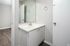 Sleek modern bathroom with minimalist design featuring a white vanity, large mirror, and elegant fixtures.