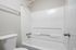 Bright, modern bathroom with sleek white fixtures, including a clean tub and shower combination.