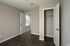 Inviting apartment bedroom with sleek hardwood floors, ample lighting, and a spacious open closet.