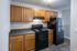 Charming kitchen with modern black appliances, sleek countertops, and elegant wooden cabinetry.