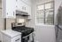 Bright, modern kitchen with sleek stainless steel appliances, fresh white cabinets, and sunlit windows.
