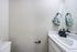 Modern bathroom with sleek white countertop, elegant black faucet, and stylish patterned hand towels for a touch of sophistication.
