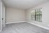 Inviting room with plush carpet, large window with blinds, and neutral walls, perfect for creating a cozy living space.
