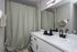 Modern bathroom showcasing sleek fixtures, spacious countertop, and stylish green-checkered shower curtain.