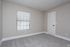 Bright, cozy bedroom with soft carpeting and large window offering natural light.