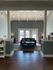 Inviting living room with high vaulted ceiling, modern lighting, and cozy seating area, leading to sunlit patio doors.