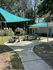 Charming outdoor area with shaded picnic tables, surrounded by lush greenery perfect for social gatherings.