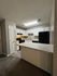Modern kitchen with sleek white cabinets, stylish countertops, and contemporary lighting for a welcoming cooking space.