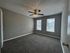 Bright, spacious bedroom with plush carpeting and large windows allowing natural light to fill the room.