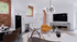 Chic community center interior with exposed brick walls, modern kitchen, and cozy living area featuring a stylish orange sofa and elegant marble fireplace.
